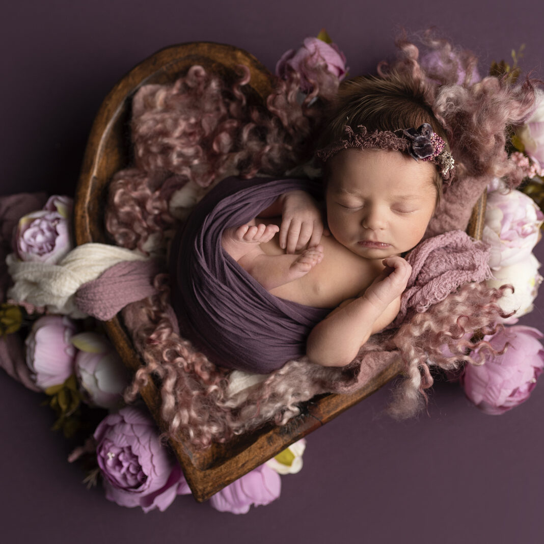 Newborn girl purple pose